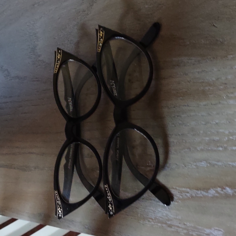 Cat eye glasses with gems around the Temple.They clear plastic  ZERO PERSCRIPTON